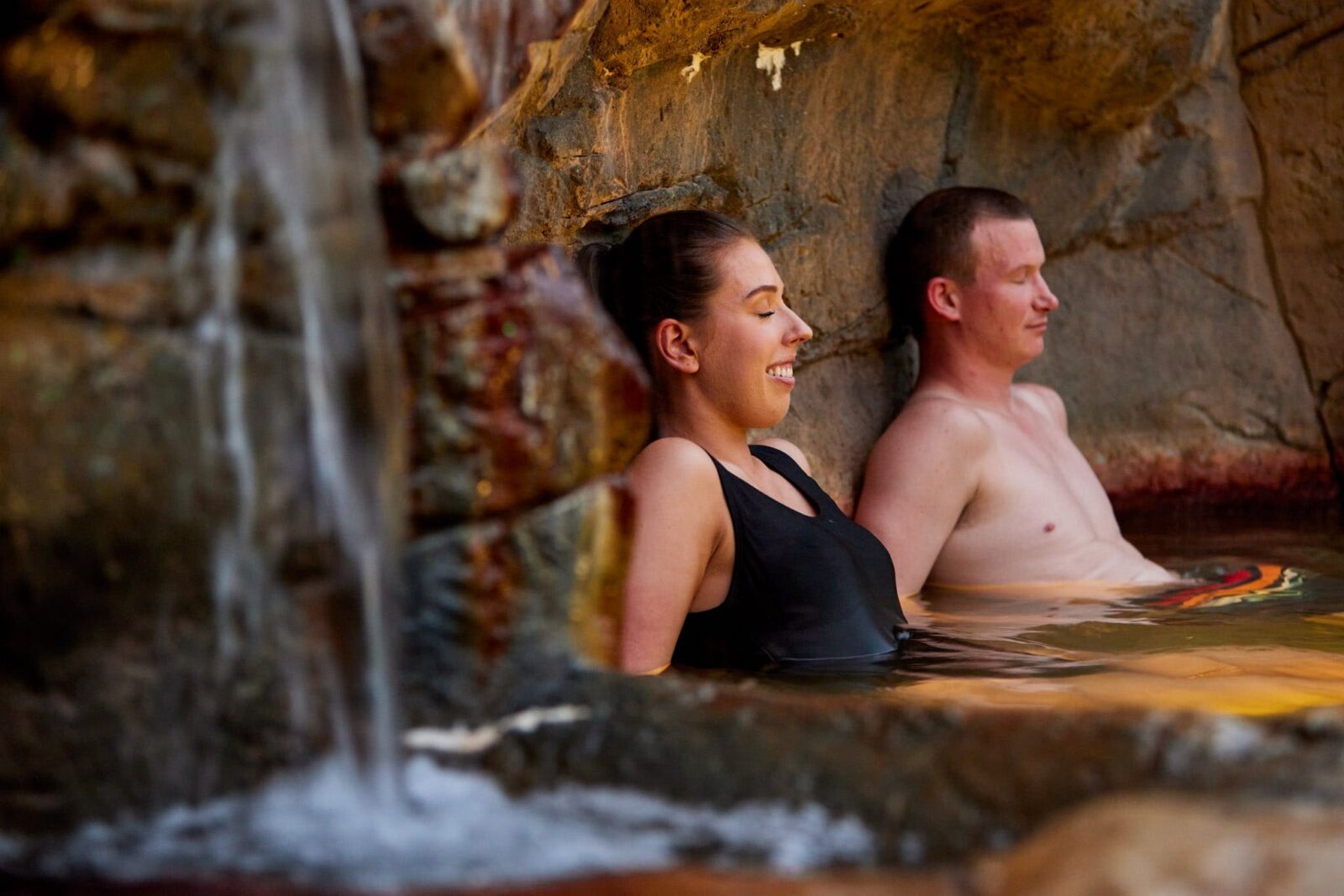 Relaxed couple bathing in Hot Springs rock pool