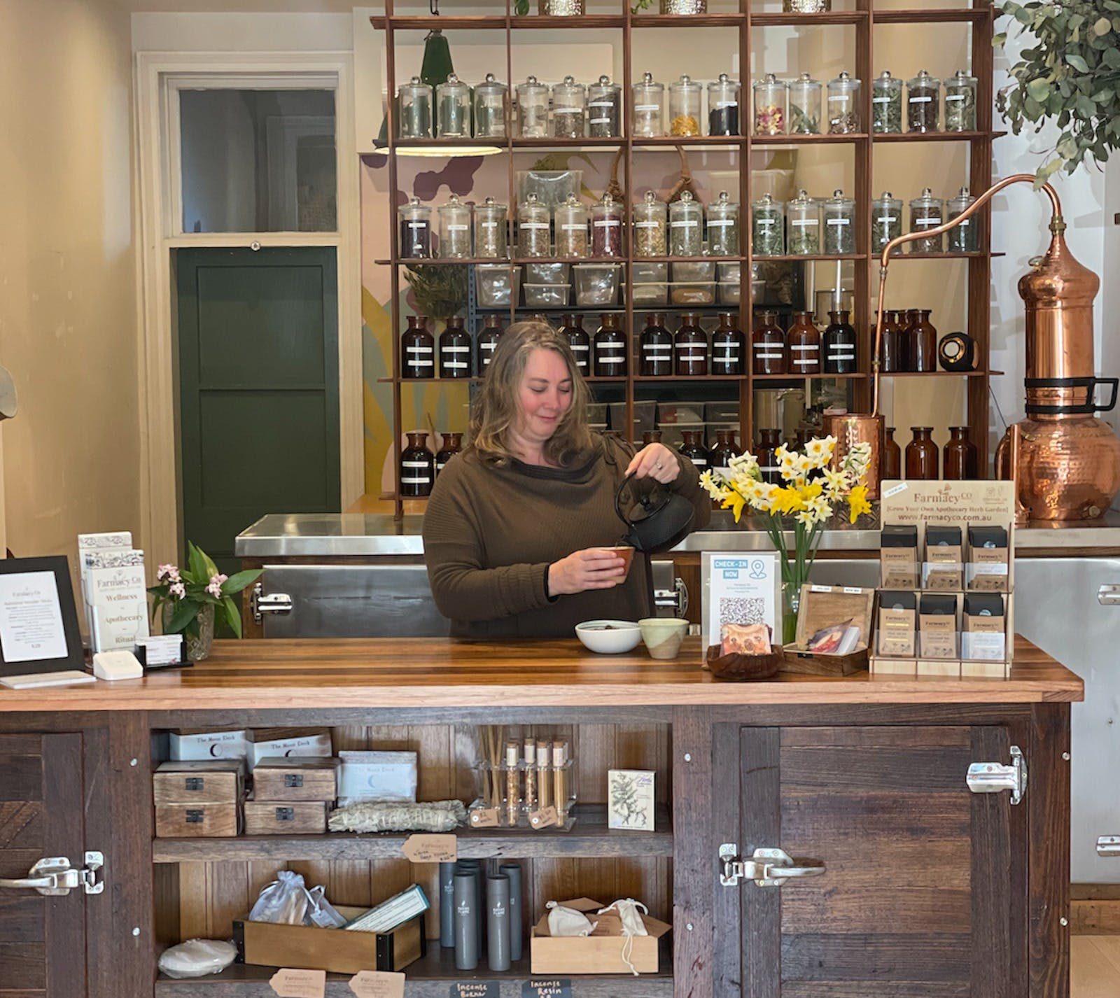 Lady standing behind a counter pouring tea