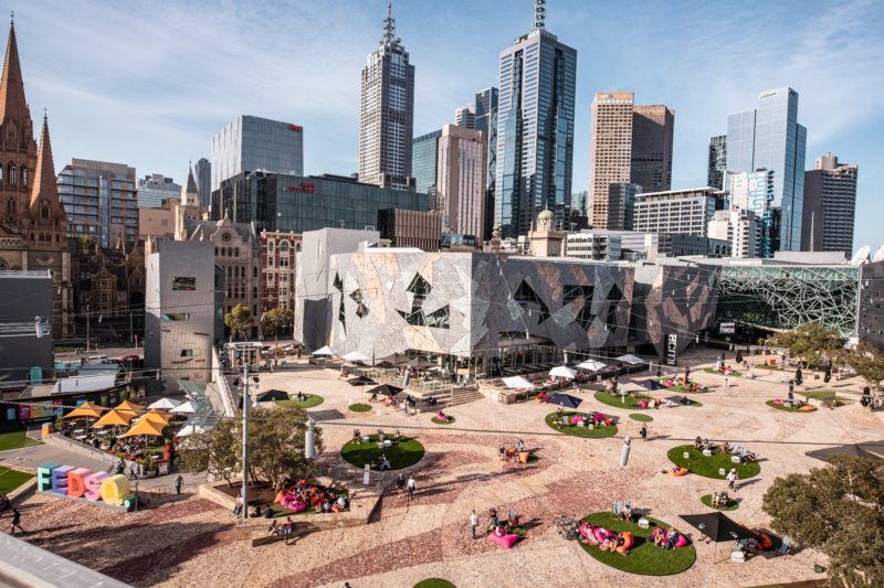 An overhead shot of Fed Square during the day. You can see the red cobblestones and unique design.