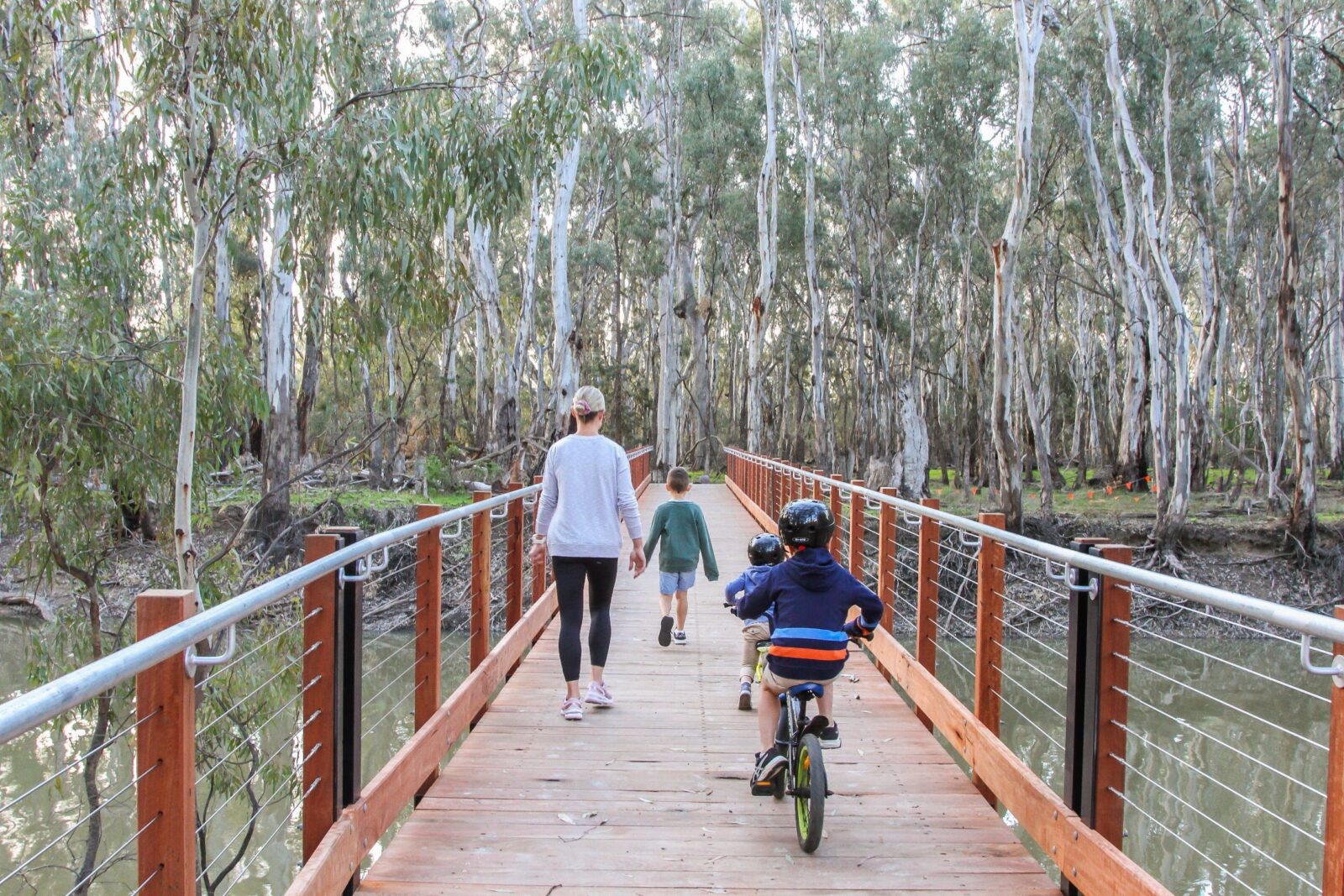 Mum and three young boys crossing the Gunbower creek on the footbridge