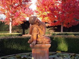 Buddha statue with autumn trees in background