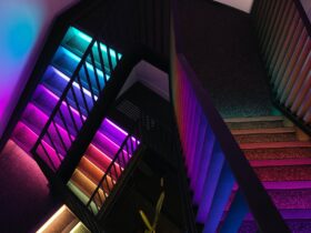 Birds eye view of three flights of stairs inside JAHM. The stairs are lit up in rainbow colours.