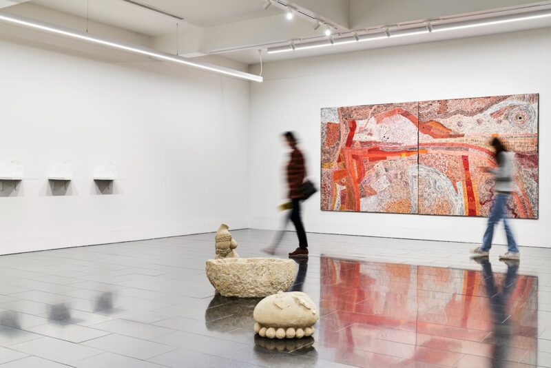 sculptures and paintings in a gallery with white walls