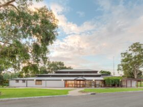 A wideangled shot of the gallery with the deck area, lawns and lemon scented gum in the foreground.