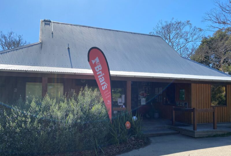 Briars Visitor Centre on a blue sky spring day with red Briars flag.