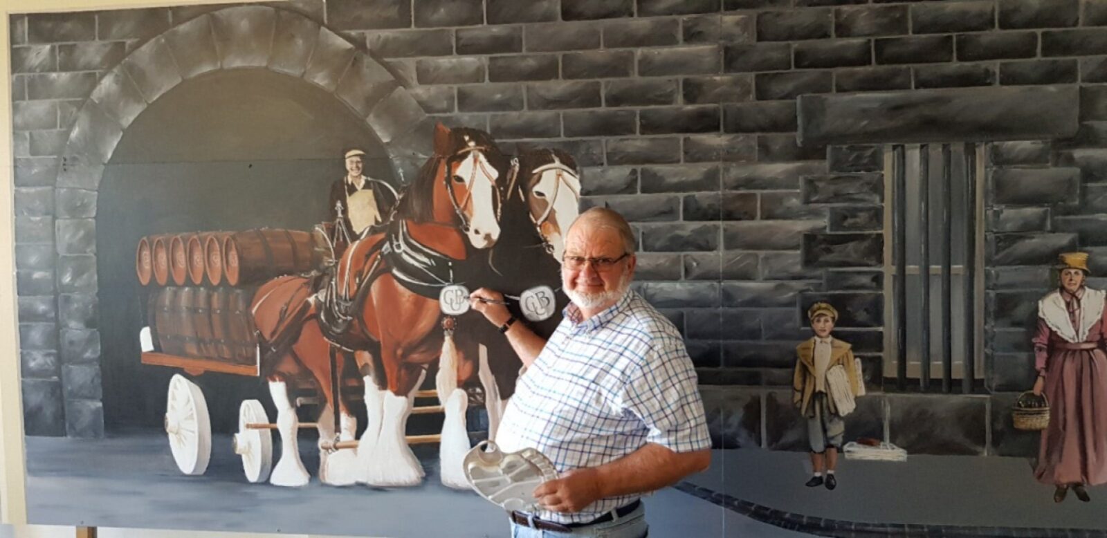 Tongala Street Art's Murray Ross is painting a mural featuring Clydesdale horses and a cart