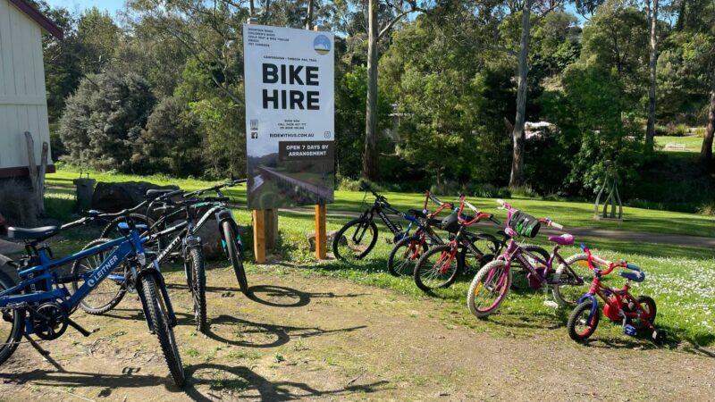 Bikes lined up in front of bike hire sign.