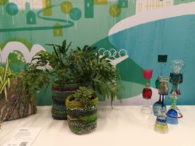 Three plant sleaves with plants made of reclaimed fibre made from tufting and glass towers .