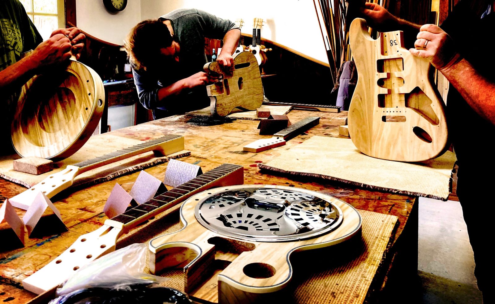 Four students building their guitars in the Electric Guitar Making Course