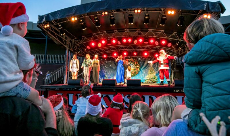 Christmas entertainers performing on a stage under lights