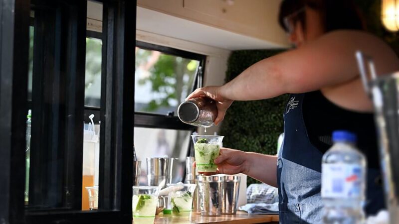 Woman in Food Truck Pouring Drink from Cocktail Shaker