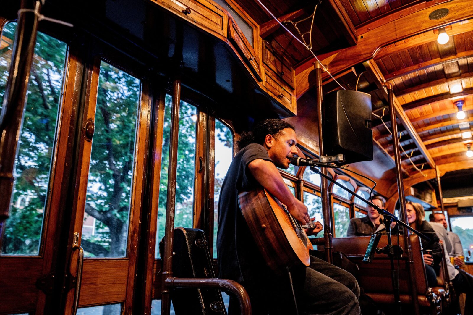Musician playing a guitar on board the Groove Tram