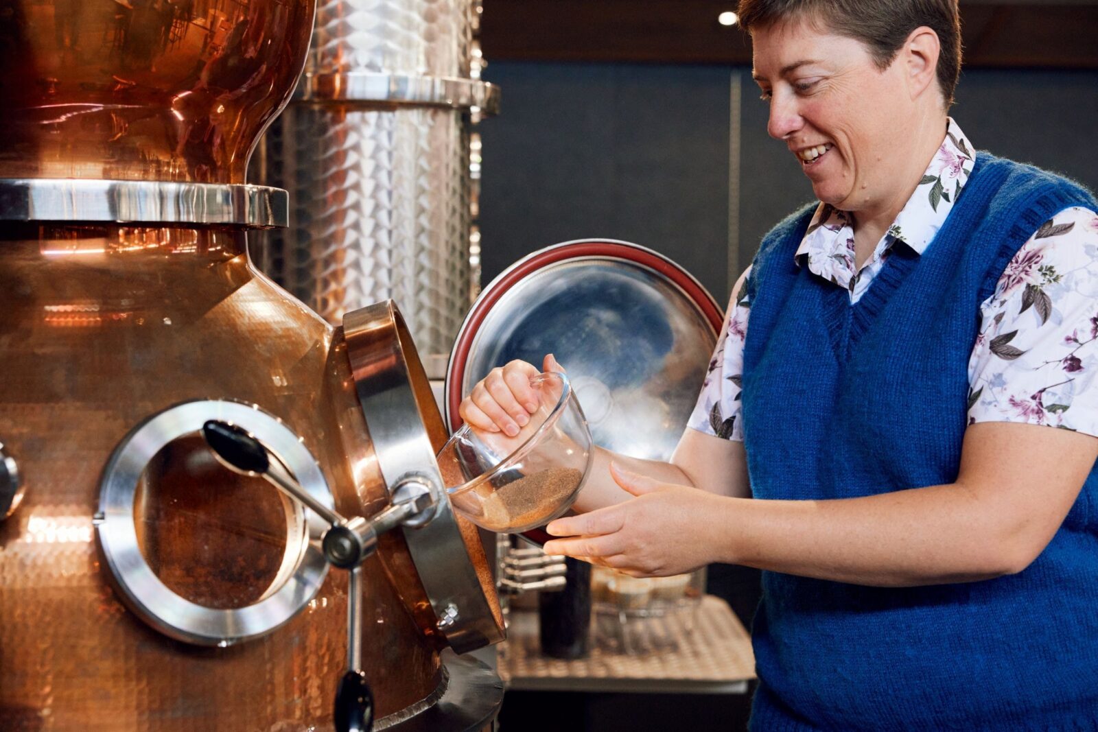 Guest putting gin botanicals into the still
