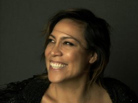 Kate Ceberano is looking to her right smiling