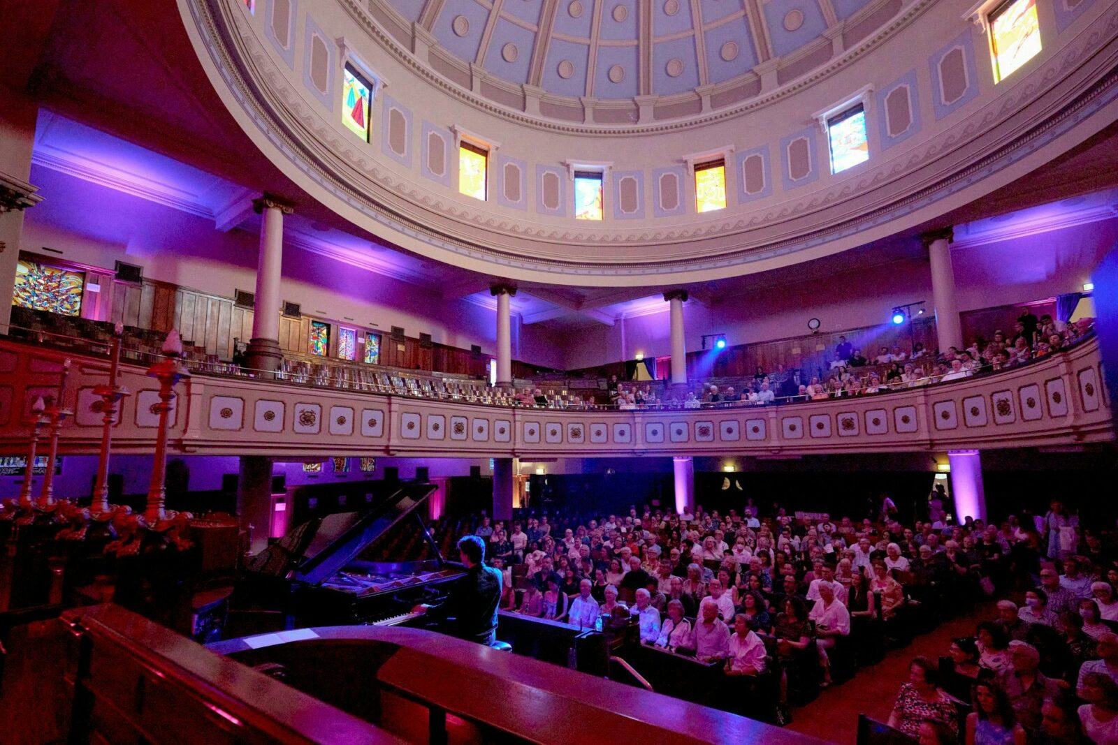 toorak synagogue, man at a piano, a dome with stained glass windows, people sitting in the audience