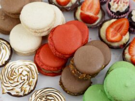 White, red, brown and green macaron and small cakes on a plate in Jacican cooking school, Gippsland