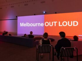 People sitting on couches in front of two screens that say Melbourne Out Loud