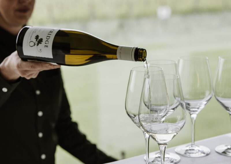 A bottle of Oakridge Chardonnay is poured into several glasses