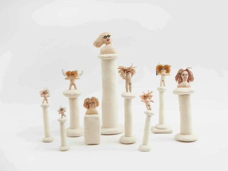 A group of 9 fabric goddess dolls on fabric plinths in varying heights