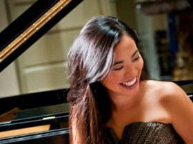 Girl laughing in front of a grand piano