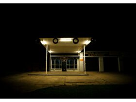 Moody photo of an empty petrol station at night dimly lit.