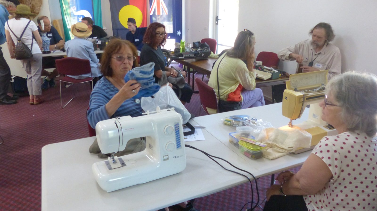 View of one of our repair cafes, with sewing machine in foreground and other fixers in background
