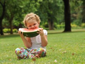 Child eating watermelon in park