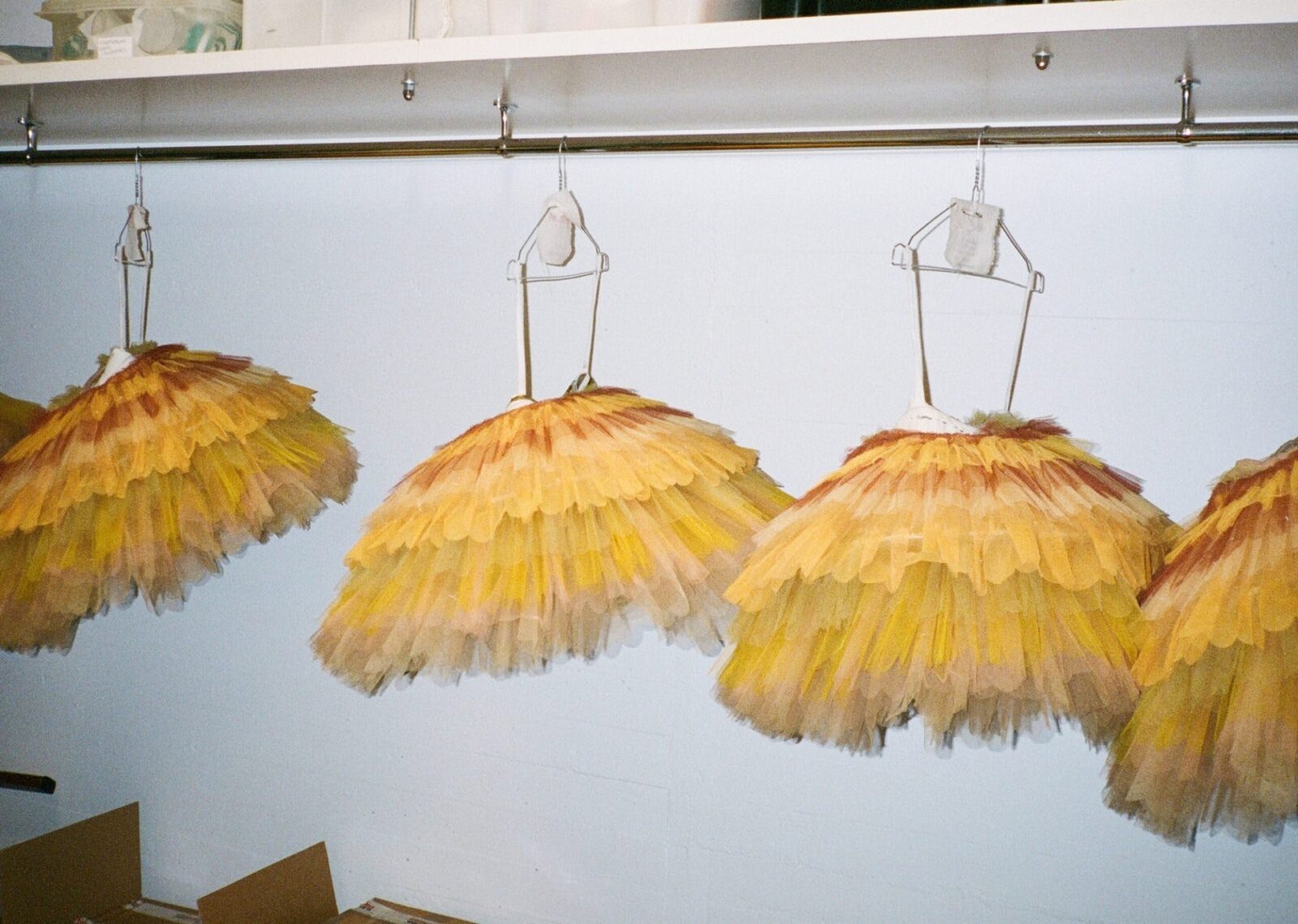 Four yellow tutus hanging in a line