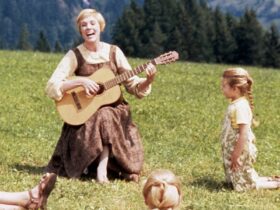 Maria teaching the Von Trapp children to sing with her guitar.