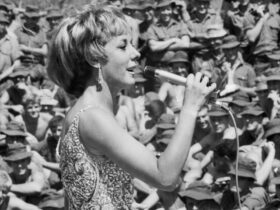 Black and white image of singer Lorrae Desmond performing to Australian soldiers in Vietnam