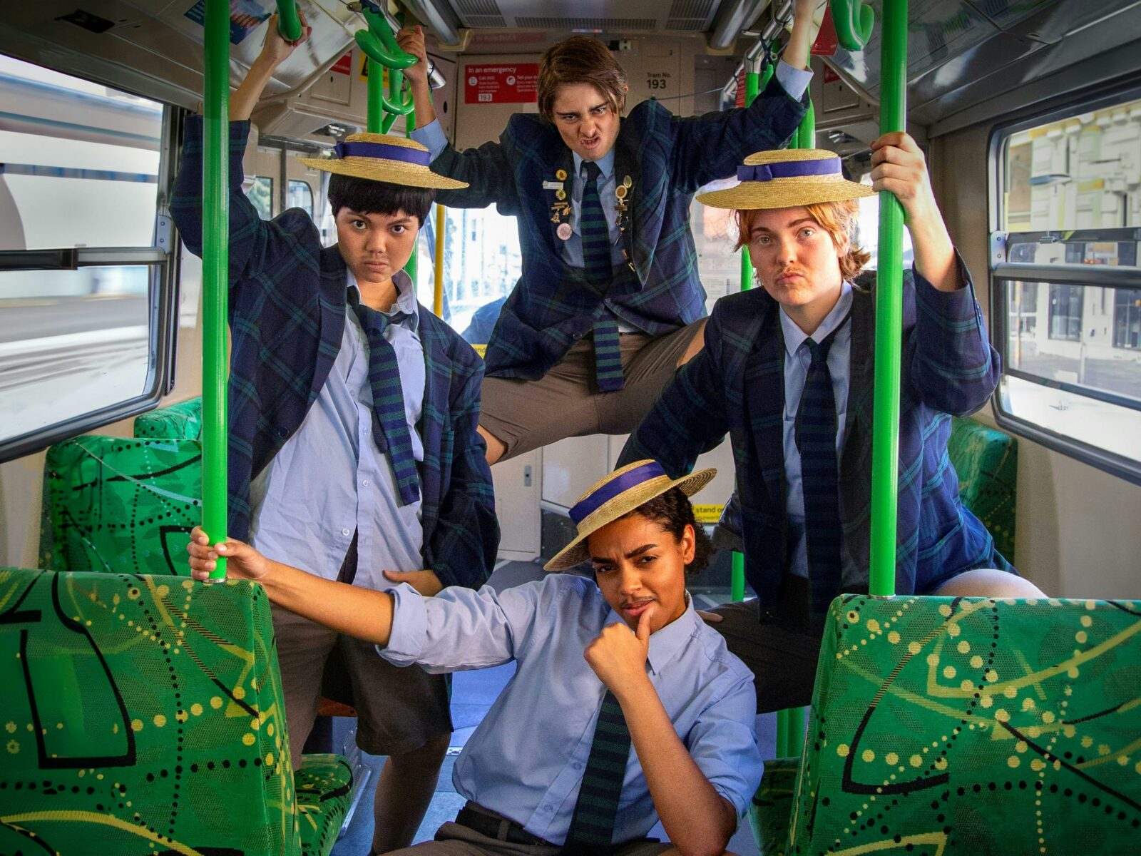 Four figures inside tram posing in school uniforms.