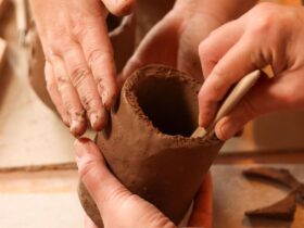 Hands moulding clay into pot