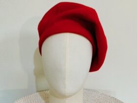 Red woollen beret sitting on a white mannequin head