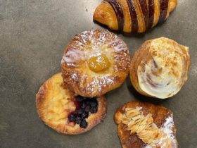 Aerial shot of five pastries, tarts and croissants on flat surface