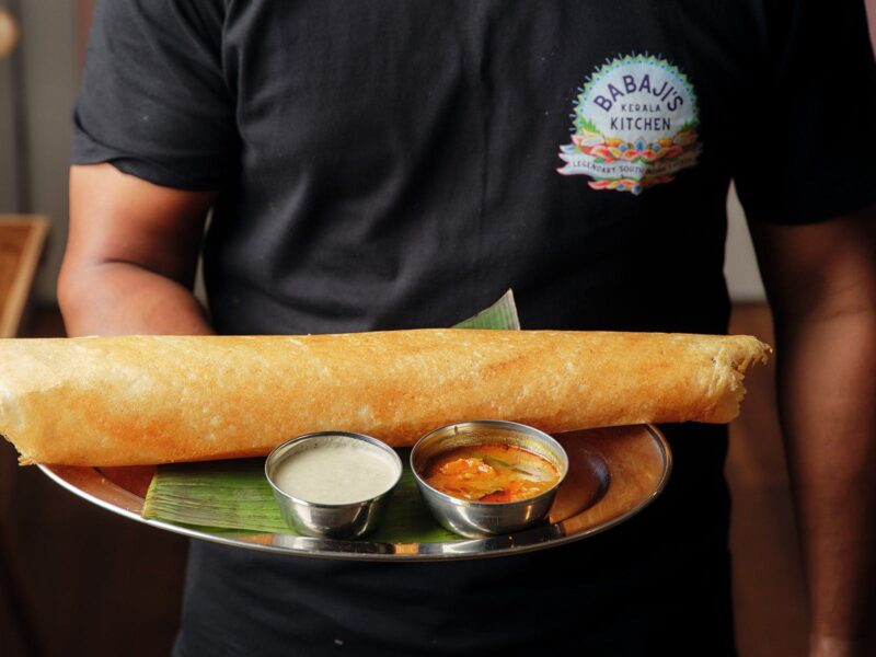 An Indian pancake is served on banana leaf with coconut chutney
