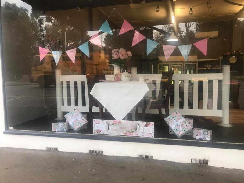shop window table and chairs table cloth bunting and wrapped gifts