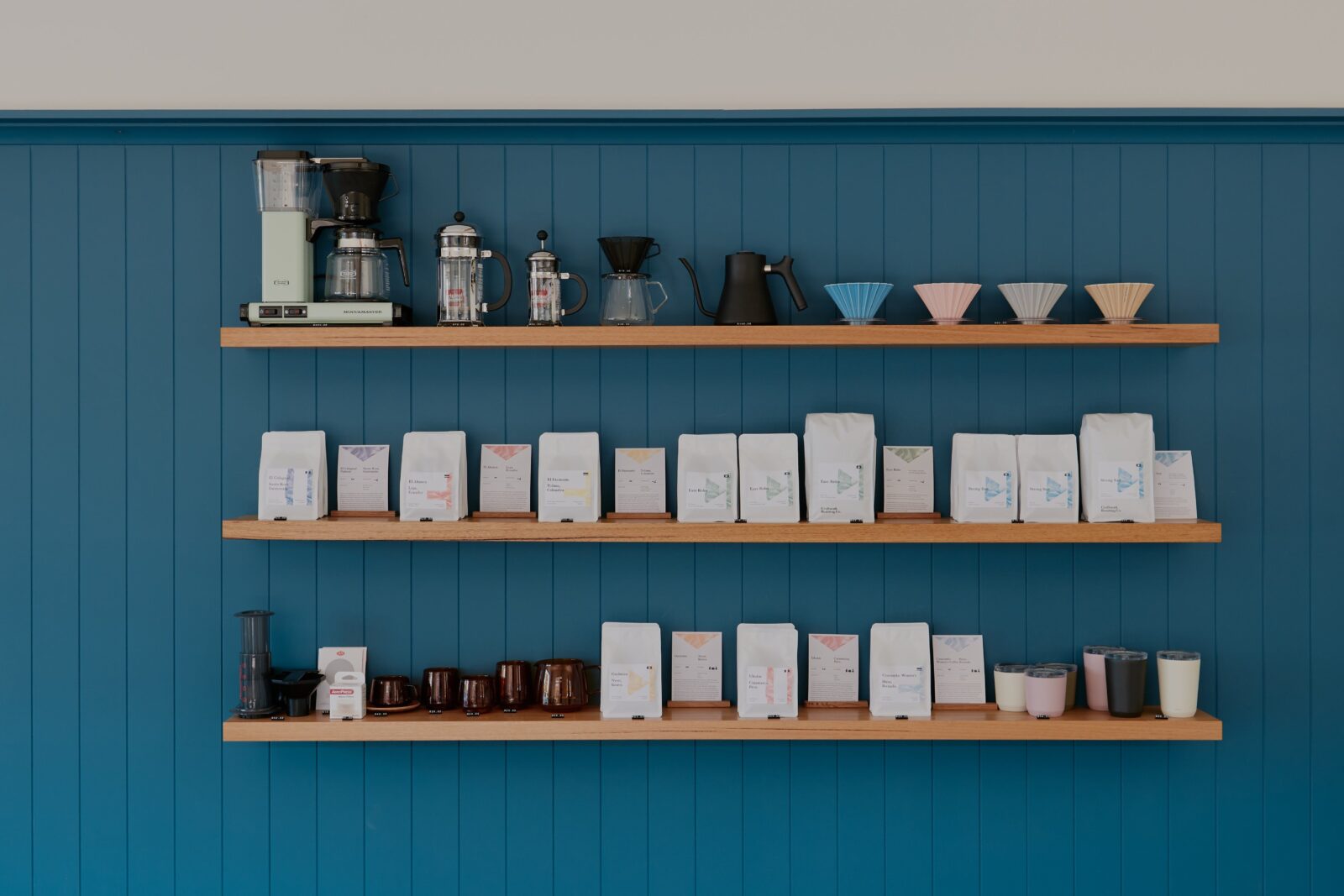 Retail shelves with bags of freshly roasted coffee and equipment
