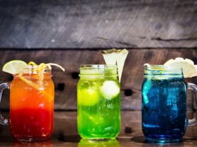 Three cocktails in jars, orange cocktail on left, green in the middle and blue on the right