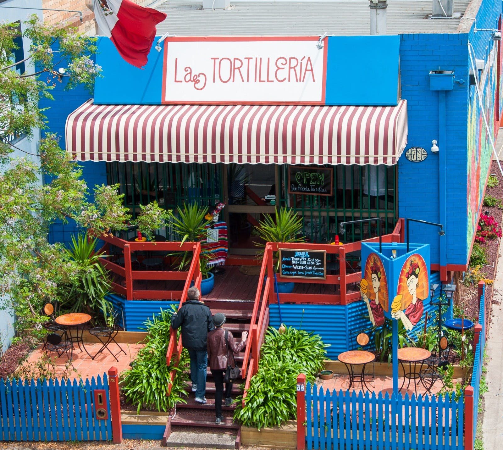Blue house with a la tortilleria sign - red font on a white background.