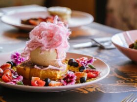 A plate of French toast topped with fairy floss and surrounded by berries