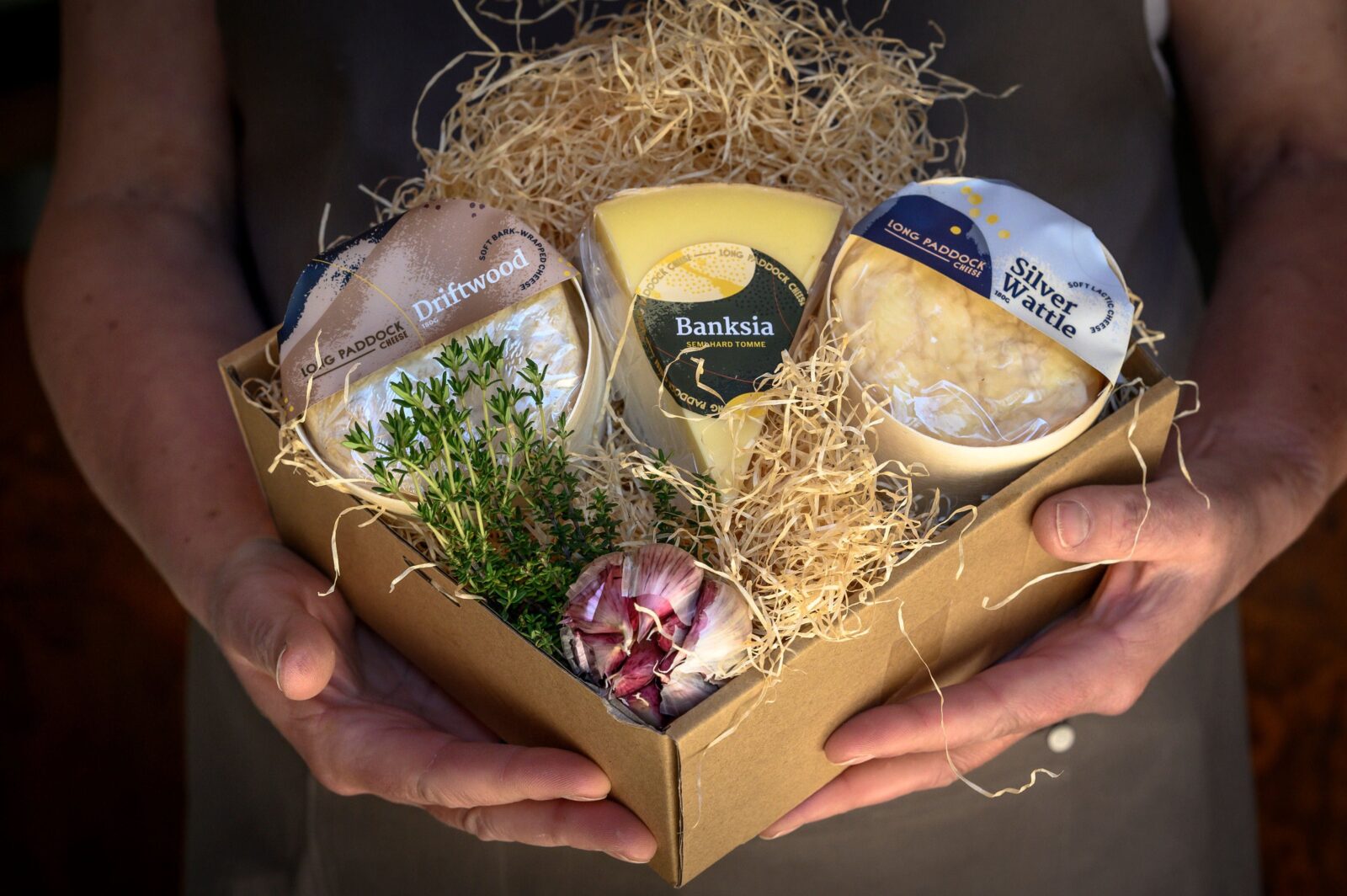 Gift box of cheese held by staff member