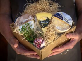 Gift box of cheese held by staff member