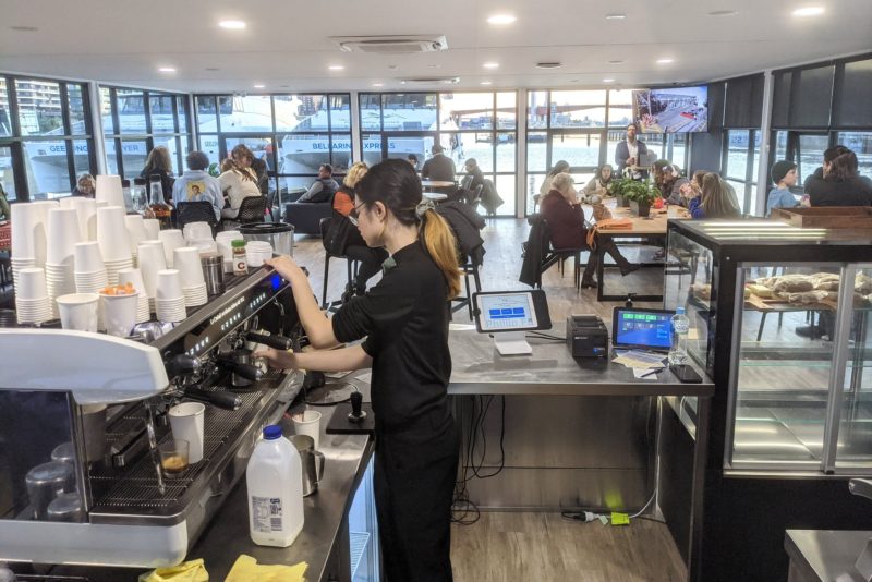 Barista making a coffee and the dining area