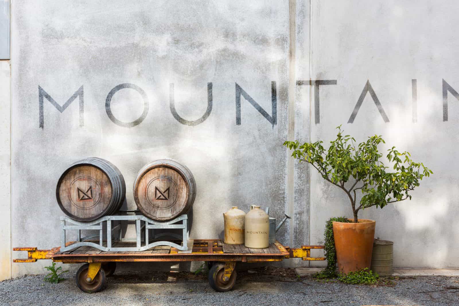 Branding piece, photo of the front of the cellar door with barrels, lemon tree and the word MOUNTAIN
