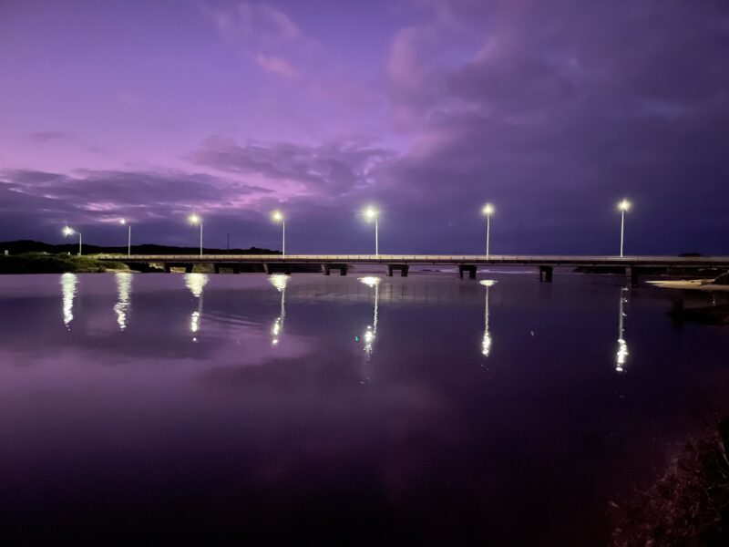 Curdies River Peterborough Bridge at sunrise. Lights on the bridge shing under a mauve purple sky.