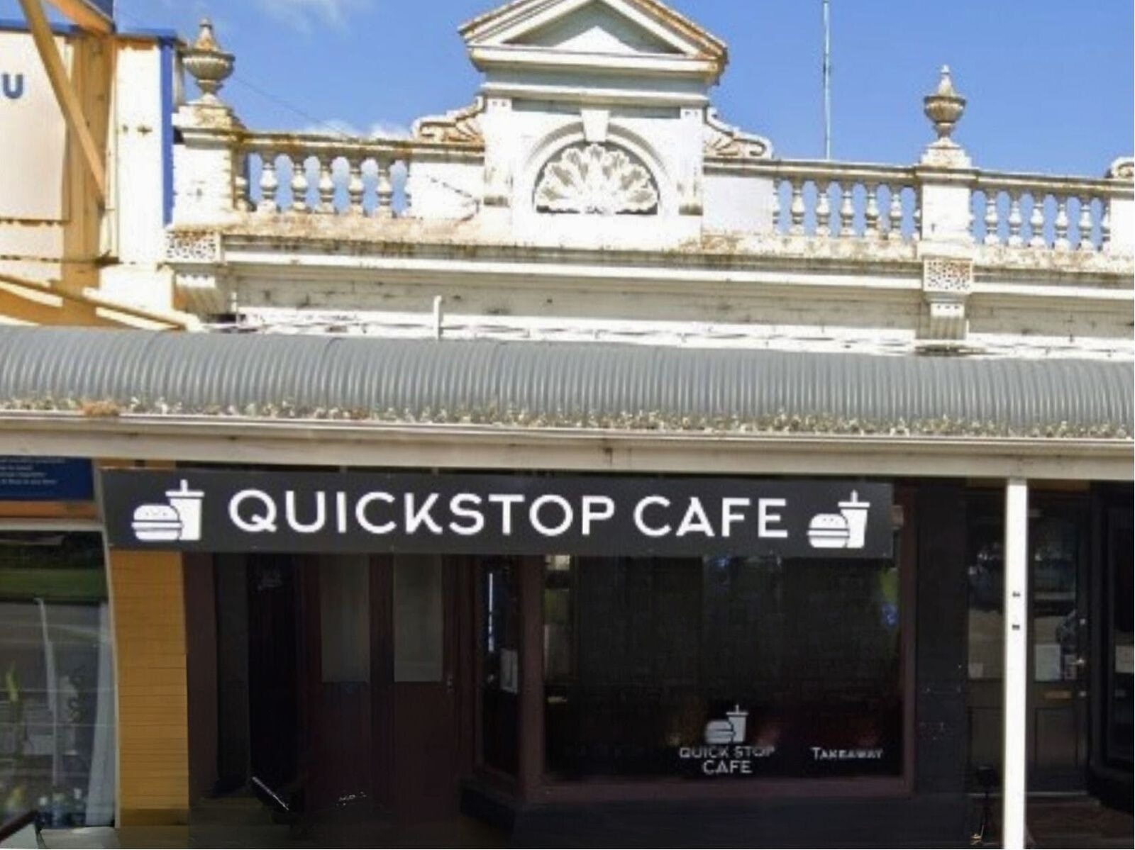 Front of the cafe with a black and white sign and large window