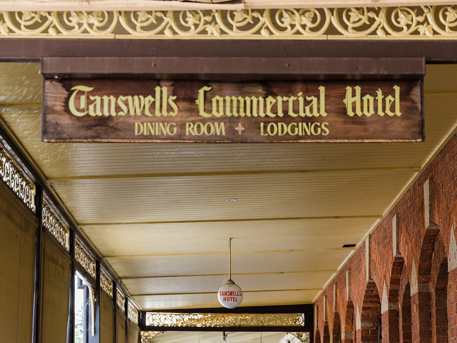 Wooden sign with gold script saying Tanswells Commercial Hotel