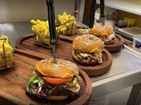 Burgers and chips on wooden boards
