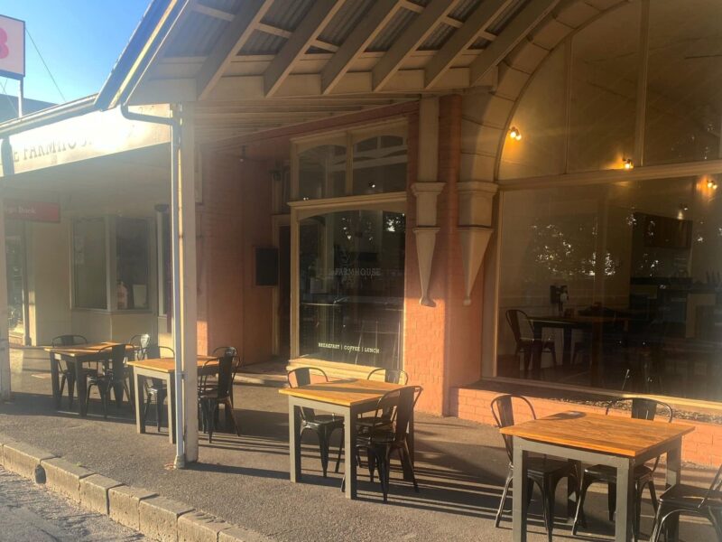 Tables on the footpath in front of the cafes large windows