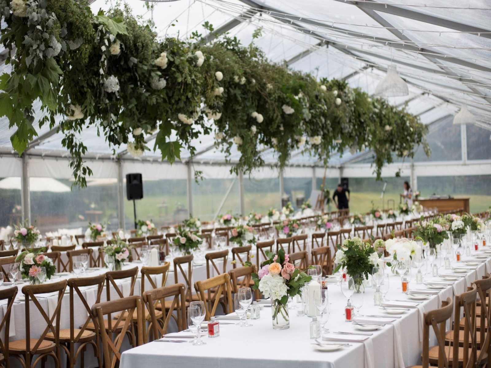 Clear Roof Marquee with long rows of banquet tables and antique oak cross back chairs